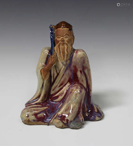 A Chinese flambé glazed pottery figure of a seated sage, early 20th century, modelled seated, his