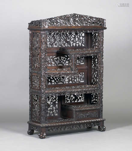 A Chinese hardwood display cabinet, early 20th century, the pediment carved and pierced with dragons