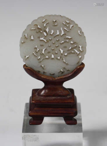 A Chinese pale celadon jade circular plaque/pendant, 20th century, carved and pierced to both