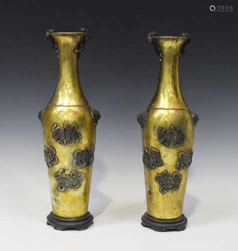 A pair of Chinese gilt metal vases, each slender tapering body applied with the eight Buddhistic