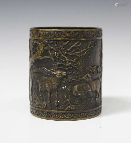 A Chinese bronze brushpot, 20th century, the cylindrical body cast in relief with goats between