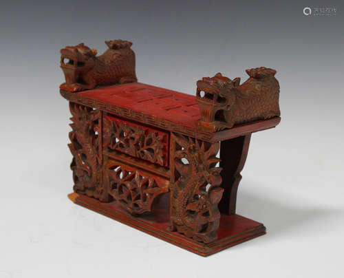 A Chinese red painted and gilt wood stand, the rectangular top with keyfret border and flanked by