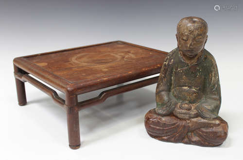 A Chinese painted carved wooden figure of a monk, Qing dynasty, modelled in a seated pose, height