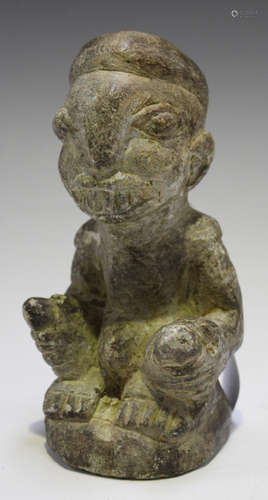 A Nomoli carved stone figure, Sierra Leone, modelled in a seated position with hands around legs,