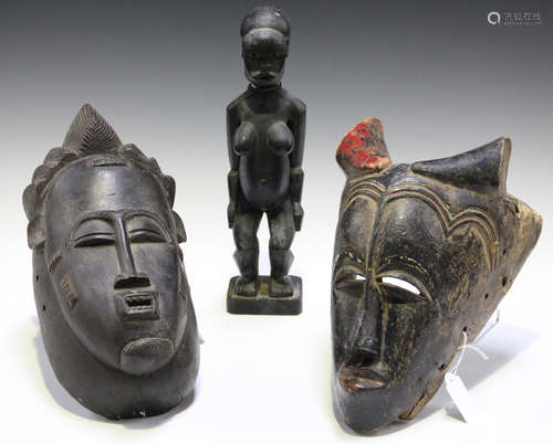 An African carved wooden mask, possibly Senufo, Ivory Coast, with black and red painted surface,