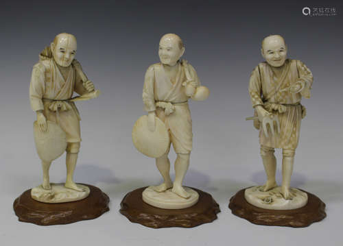 A group of three Japanese carved ivory okimono figures of a fisherman and two farmers, Meiji period,