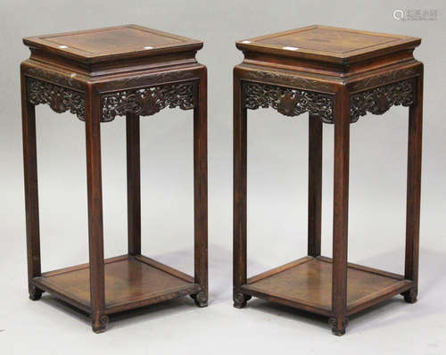 A pair of Chinese hardwood stands, 20th century, each with square panelled top above a carved and