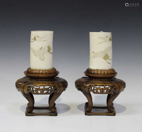 A pair of Japanese ivory tusk vases and wood stands, Meiji period, each tusk section incised and