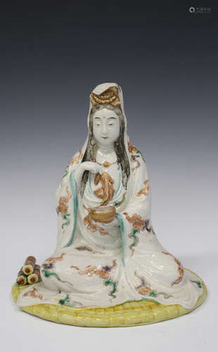 A Japanese Kutani porcelain figure of Kannon, Meiji period, modelled seated wearing a long robe,