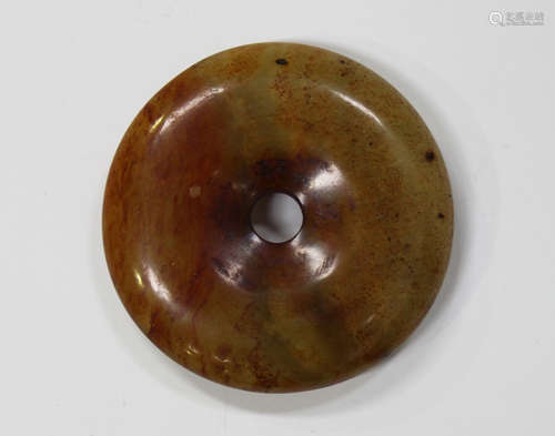 A Chinese jade disc (bi), Qing dynasty, of plain circular form with central pierced aperture, the