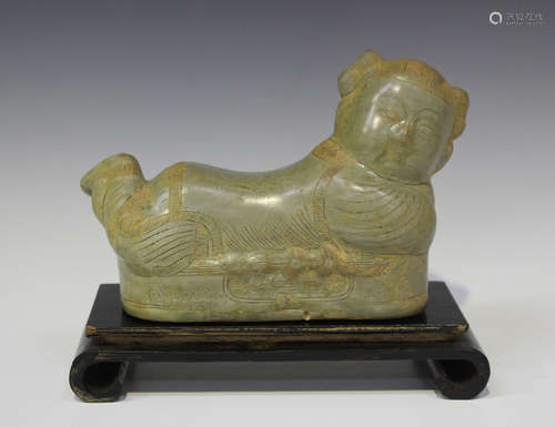 A Chinese Song style celadon glazed pottery pillow, modelled as a recumbent boy, length 22.5cm (