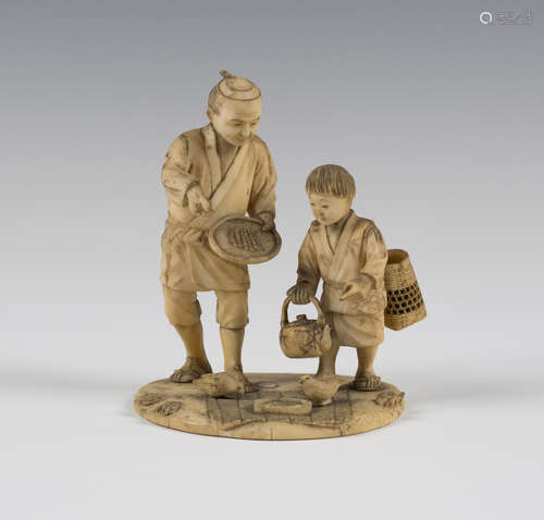 A Japanese ivory okimono figure group, Meiji period, modelled as a father and son feeding two birds,