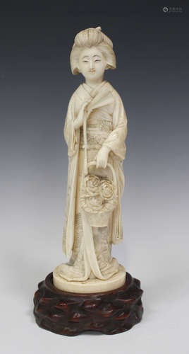 A Japanese carved ivory okimono figure of a bijin, Meiji period, the standing maiden modelled