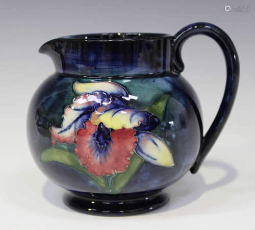 A Moorcroft pottery Orchid pattern jug, mid-20th century, with shaded blue ground, impressed marks