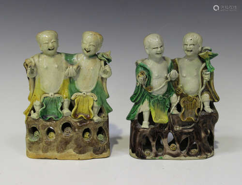 Two Chinese sancai enamelled biscuit porcelain figure groups of Hehe Erxian, Kangxi period, each