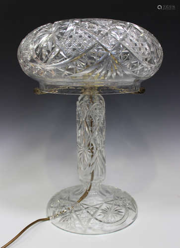 A cut glass table lamp, mid-20th century, the mushroom shaped shade supported on metal arms above