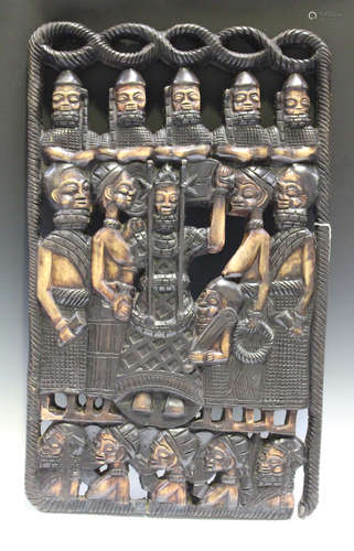 An African carved and stained wooden panel, modelled with a procession of tribal figures, 87cm x