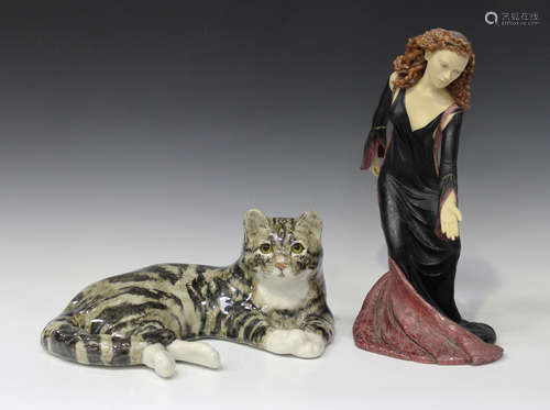 A Winstanley pottery recumbent cat, 20th century, with mottled grey decoration and yellow glass