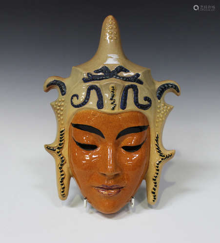 An Art Deco style pottery wall mask in the form of a Thai dancer wearing a traditional headdress,