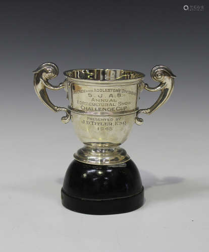 A George VI silver two-handled trophy cup of girdled 'U' form, flanked by a pair of flying scroll