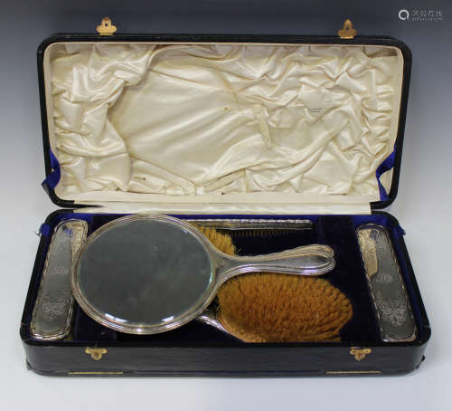 A George V silver six-piece dressing table set, comprising a handmirror, two hairbrushes, two
