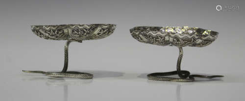 A pair of Indian white metal bonbon dishes, each in the form of a snake supporting a lobed bowl, the