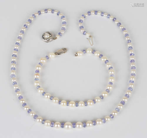 A single row necklace of graduated cultured pearls alternating with faceted tanzanite beads, on a