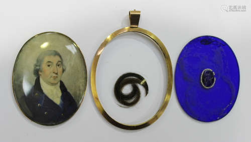 An oval portrait miniature of a gentleman wearing a blue jacket, within a gold mounted glazed oval