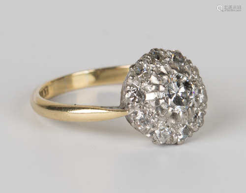 A gold, platinum and diamond cluster ring, claw set with the principal circular cut diamond within a