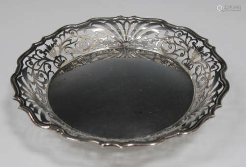 A late Victorian silver circular footed dish with scroll pierced sides, raised on scroll legs,