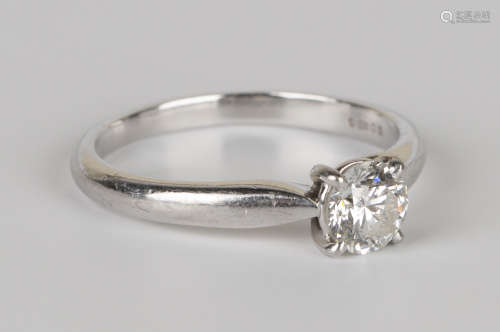 A platinum and diamond single stone ring, claw set with a round brilliant cut diamond, ring size