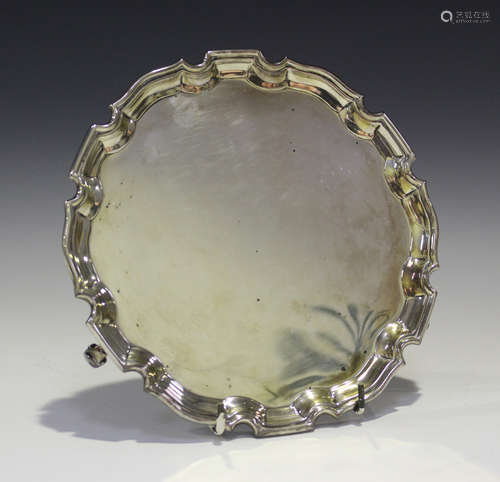 An Elizabeth II silver card salver with piecrust rim, on volute scroll feet, Birmingham 1958 by Adie