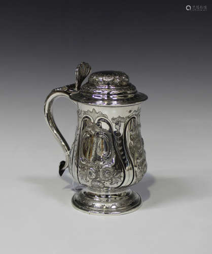 An early Victorian silver tankard of baluster form with domed hinged lid, embossed and engraved with