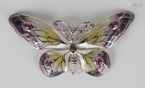 A silver and plique-à-jour brooch in the form of a butterfly with diamond set eyes and garnet set