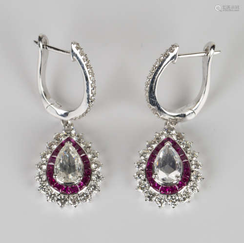 A pair of white gold, diamond and ruby pendant earrings, each pear shaped drop claw set with the