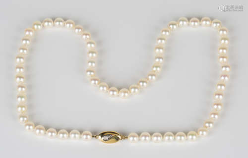 A single row necklace of uniform cultured pearls on an 18ct gold and diamond oval shaped clasp,
