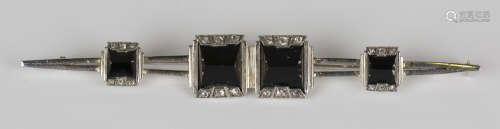 An onyx and diamond set bar brooch, mounted with four graduated square cut onyx within diamond set