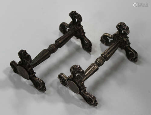 A pair of Victorian silver knife rests, each turned and fluted bar supported by scroll ends,