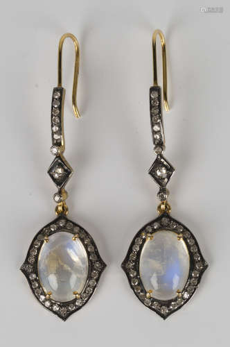 A pair of gold, silver, moonstone and diamond pendant earrings, each claw set with an oval moonstone