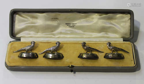 A set of four George V silver menu holders, each in the form of a pheasant on an oval base,