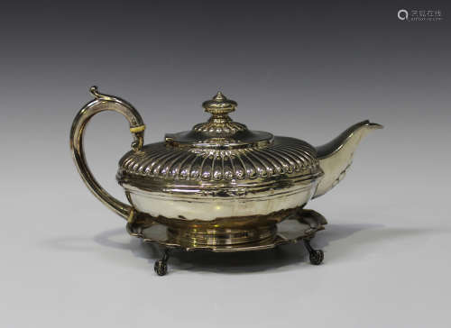 A William IV silver teapot of squat circular form with half-reeded decoration, London 1831 by