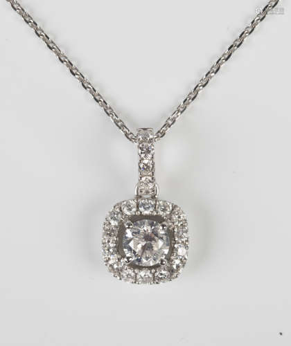 A white gold and diamond pendant, claw set with the principal circular cut diamond within an open