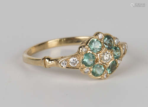 A gold, diamond and emerald cluster ring, mounted with the principal circular cut diamond within a