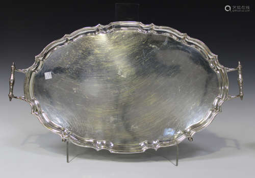 A George V silver two-handled oval tray with piecrust rim, raised on pad feet, Chester 1925 by