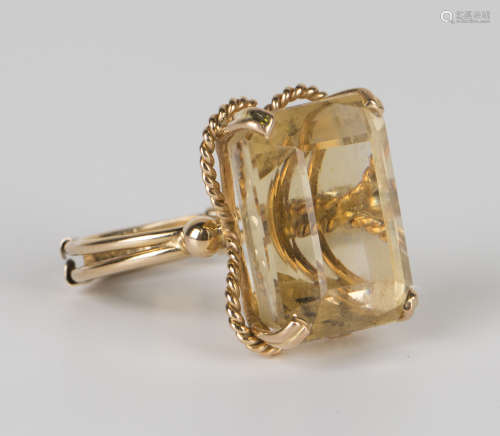 A gold and citrine single stone ring, claw set with a cut cornered rectangular step cut citrine,