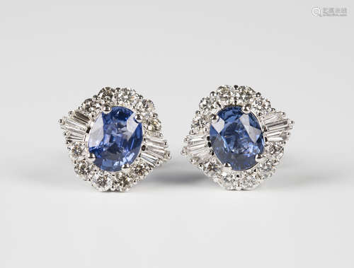 A pair of 18ct white gold, sapphire and diamond cluster earrings, each claw set with an oval cut