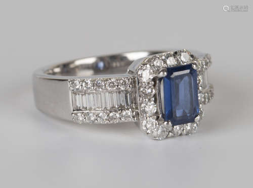 An 18ct white gold, sapphire and diamond ring, claw set with a rectangular cut sapphire within a