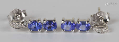 A pair of white gold, tanzanite and diamond pendant earrings, each claw set with two oval cut