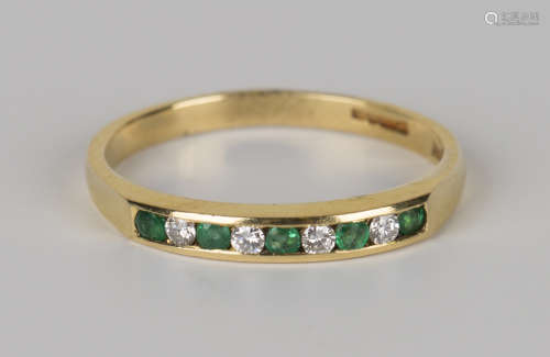 An 18ct gold, emerald and diamond half-hoop ring, mounted with five circular cut emeralds