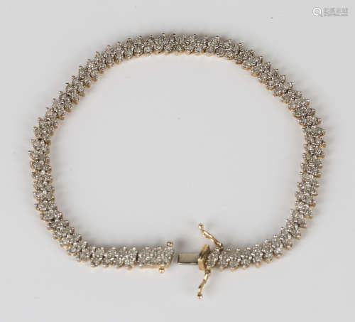 A 9ct gold and diamond bracelet, formed as a row of diamond set two stone links in a slanting